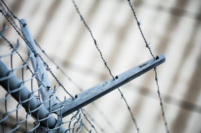 Outdoor Fence Detail of Sharp Barbwire Installation. Security and Protection Concept